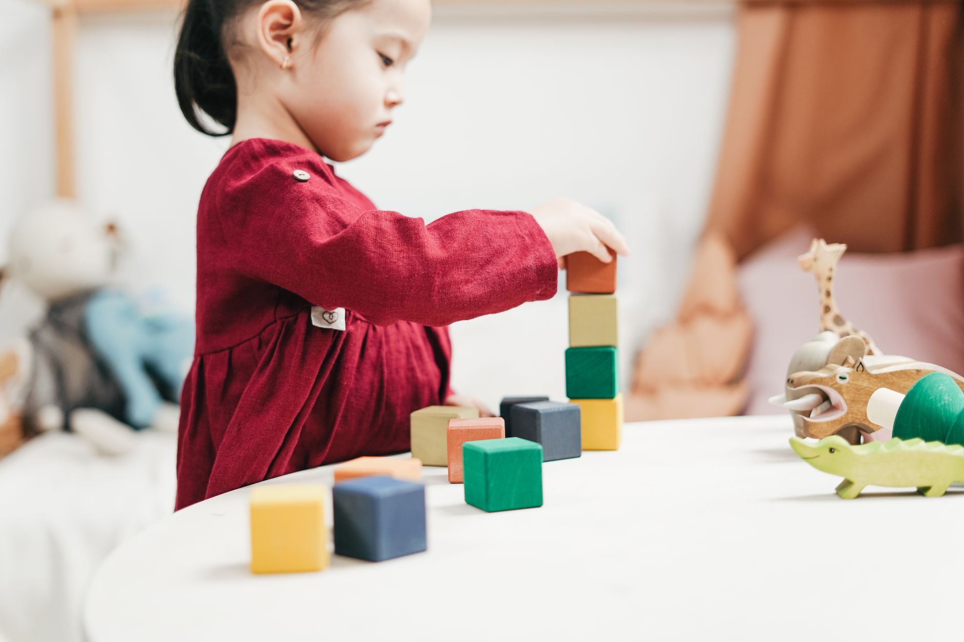 A young girl playing with colourful wooden blocks